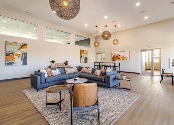A living room with a grey couch, a round table, and a rug.