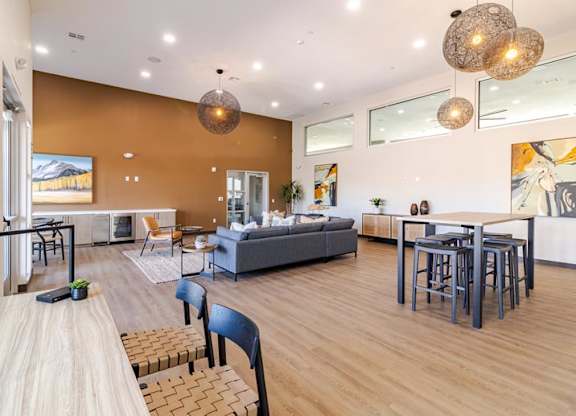 A modern living room with a grey sofa and a wooden dining table.