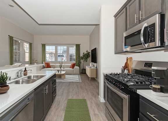 A modern kitchen with a stove top oven and a microwave above the counter.