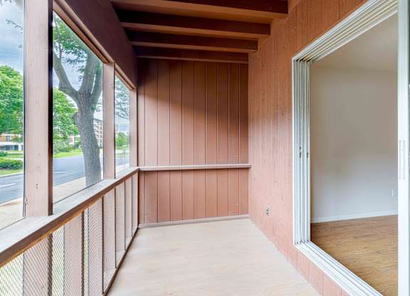 A room with wooden walls and a glass door.