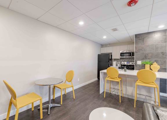 A kitchen with a table and chairs.