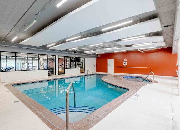 A large indoor swimming pool with a glass wall on one side.