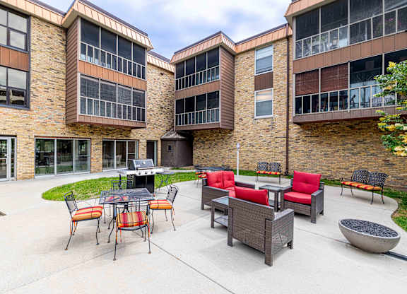 A patio area with a table and chairs in front of a brick building.