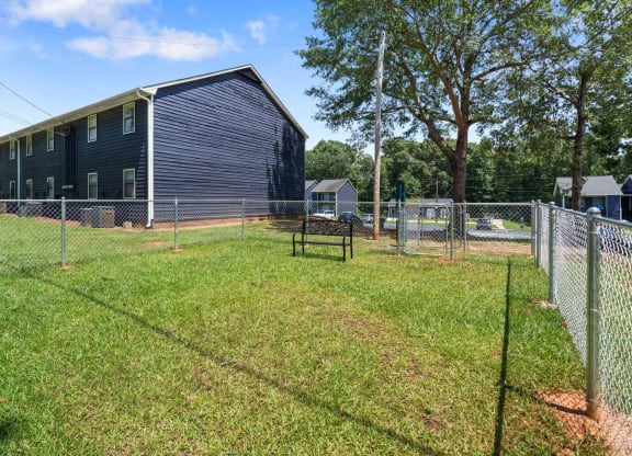 a fenced in dog park with a barn in the background at Alcovy Terrace, Georgia