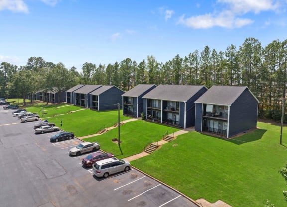 a row of houses with a grassy area and trees in the background at Alcovy Terrace, Covington, Georgia, 30014