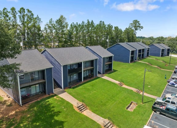 a row of blue houses with a grassy area at Alcovy Terrace, Covington, Georgia, 30014