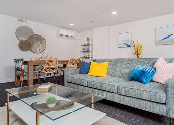 A living room with a blue couch and a glass coffee table. at Oak Park City, Oak Park