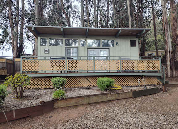 View of a cabin with a deck surrounded by trees at Salinas Sunset Apartments, California