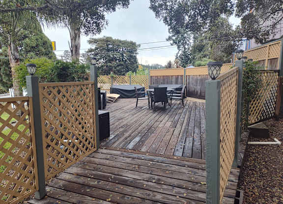 A wooden deck with a lattice fence and a table and chairs at Salinas Sunset Apartments, Salinas, 93907