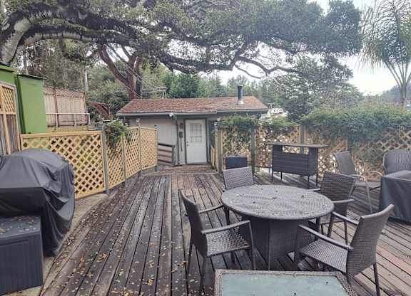 A wooden deck with a table and chairs at Salinas Sunset Apartments, Salinas, California