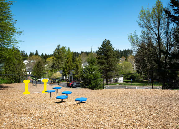 a park with a playground and blue benches at Murrayhill Park, Oregon