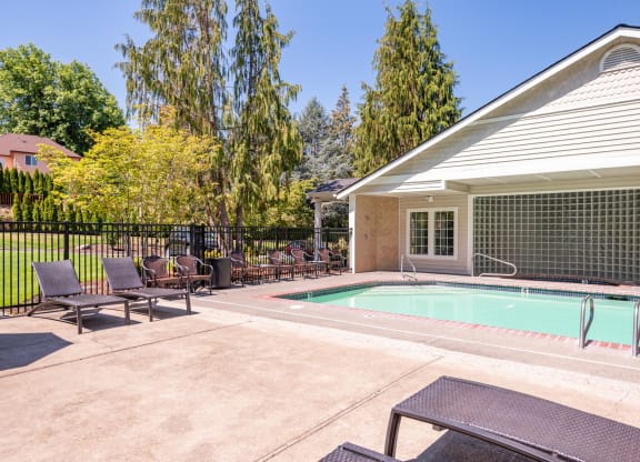 a swimming pool in front of a house with patio furniture at Murrayhill Park, Beaverton Oregon