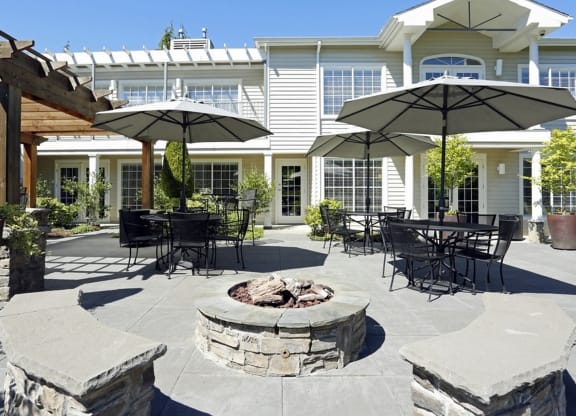 a patio with tables and umbrellas and a fire pit at Murrayhill Park, Beaverton, OR 97008