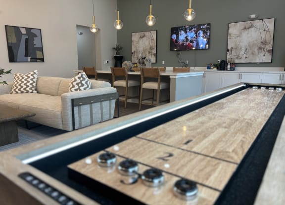 Clubhouse with shuffleboard table and a kitchen with a television