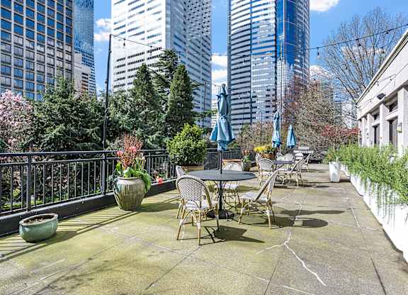 A patio with a table and chairs overlooks a cityscape at The Exeter Apartments, Seattle