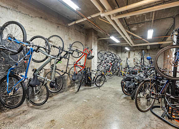 A bike storage with many bikes hanging on the wall at The Exeter Apartments, Washington