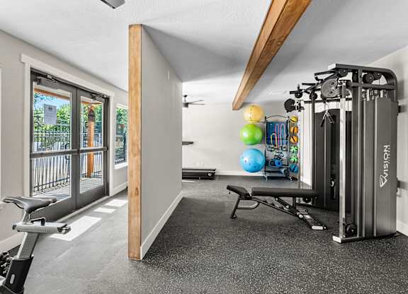 A home gym with a treadmill, exercise balls, and weights.