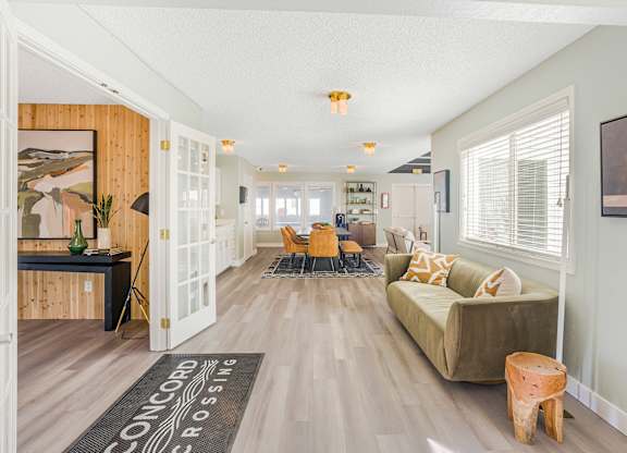 A large room with a couch, chairs, and a rug that says Concord Crossing.