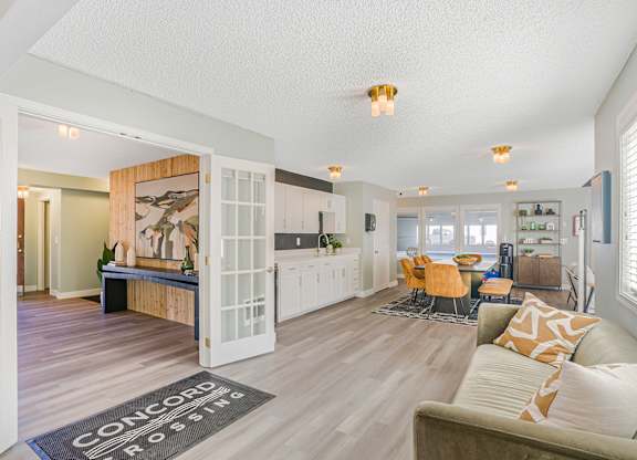 A large room with a couch and table with a rug that says Concord Crossing