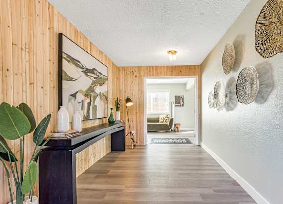 A hallway with a wooden wall and a bench with a mirror above it.
