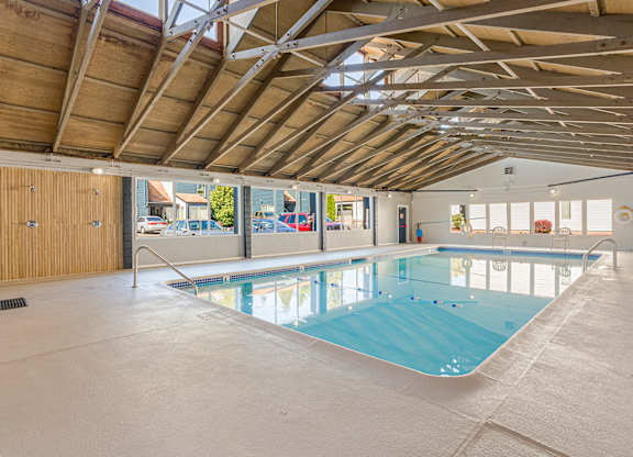 A large indoor swimming pool with a wooden ceiling.