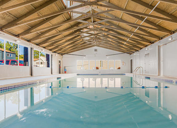 A large indoor swimming pool with a wooden ceiling.