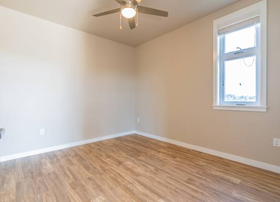Empty bedroom with wood flooring and ceiling fan at Brooklyn Yard Apartments, Portland, 97202