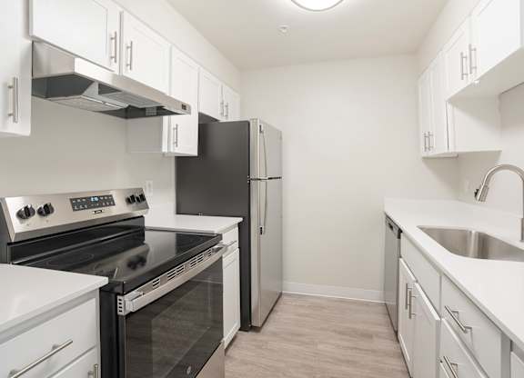 A kitchen with black appliances and white cabinets.