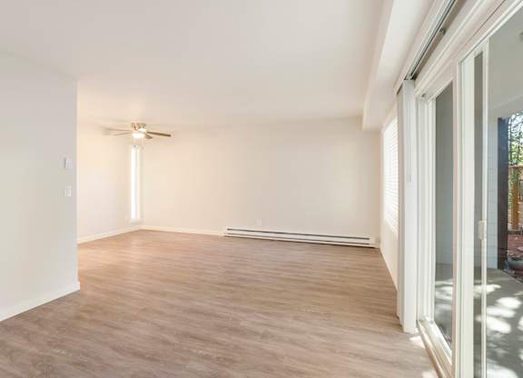 A room with a ceiling fan and a sliding glass door.
