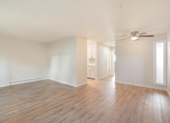 A large room with hardwood floors and a ceiling fan