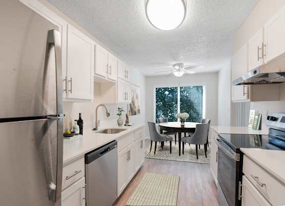 A kitchen with a table and chairs in the middle.