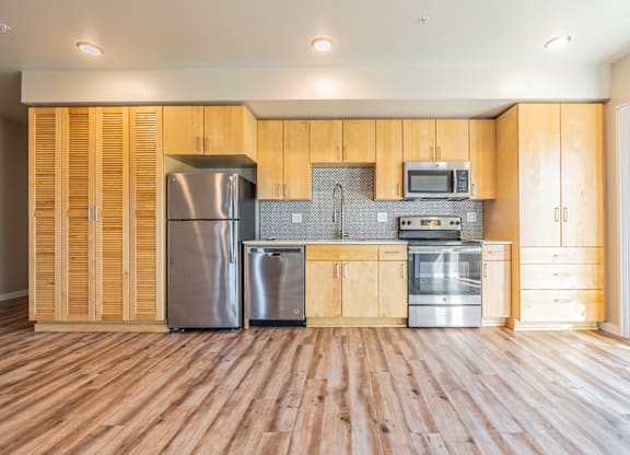 Modern kitchen with light wood cabinets and stainless appliances at Brooklyn Yard Apartments, Portland
