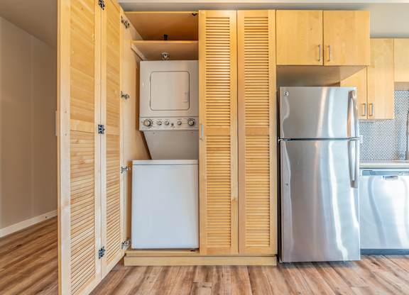 Stacked washer dryer behind louvered cabinet doors at Brooklyn Yard Apartments, Oregon, 97202