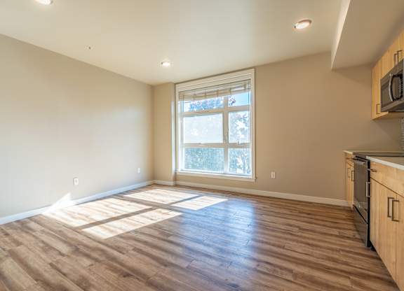 Empty living space with large window and natural light at Brooklyn Yard Apartments, Portland, 97202