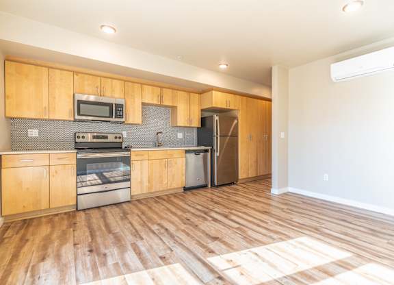 Open kitchen with light maple cabinets and wood floors at Brooklyn Yard Apartments, Portland