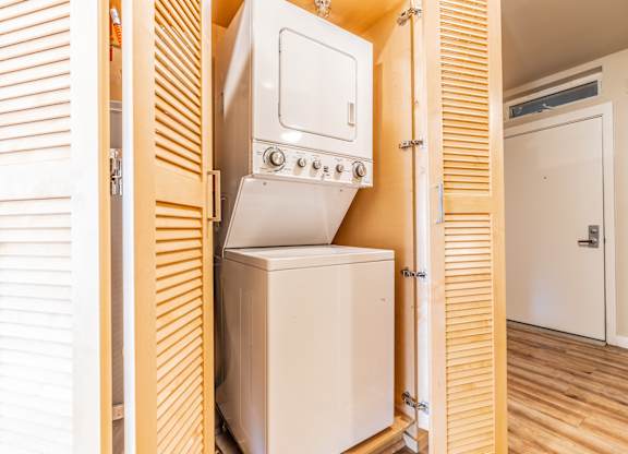Stacked washer dryer unit in closet with louvered doors at Brooklyn Yard Apartments, Portland, 97202