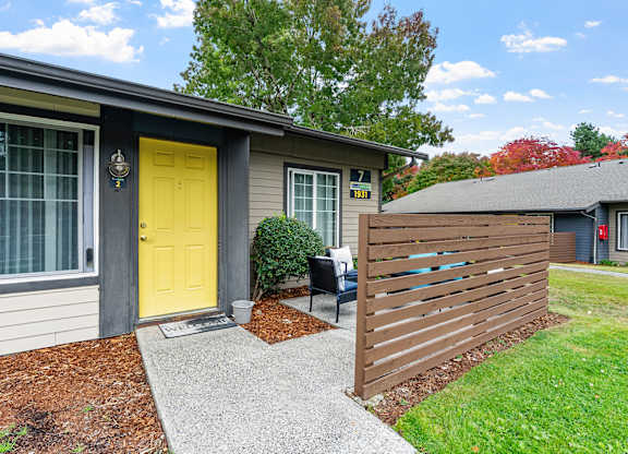 Apartment exterior with a yellow door and patio