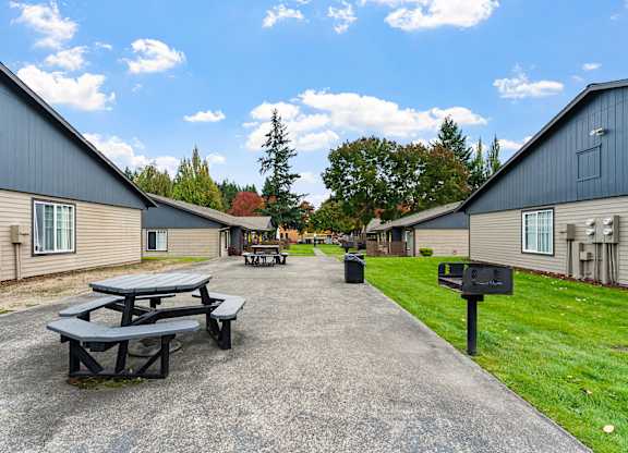A picnic table is in the middle of a courtyard between two apartment buildings.
