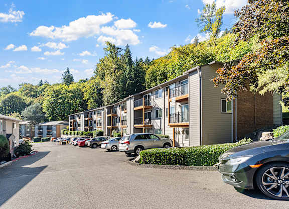 Apartment exteriors with a parking area and trees