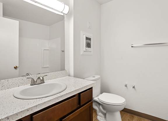 A white toilet sits next to a sink in a bathroom.
