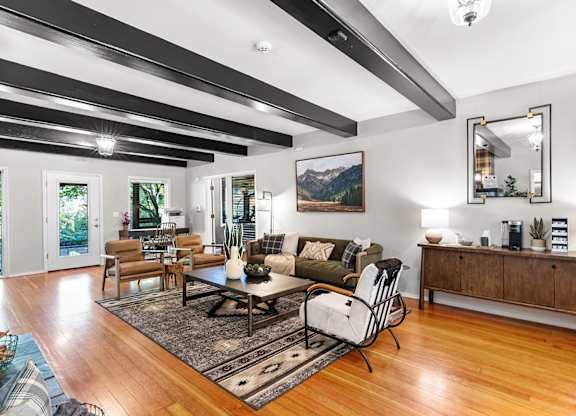 A sitting room with a black and white striped ceiling and a large painting on the wall.