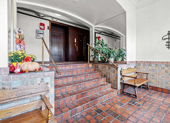 A hallway with a bench and a plant.