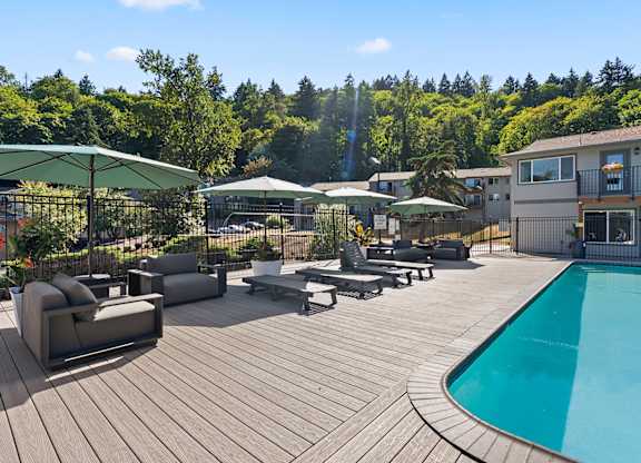A wooden deck with a pool and patio furniture.
