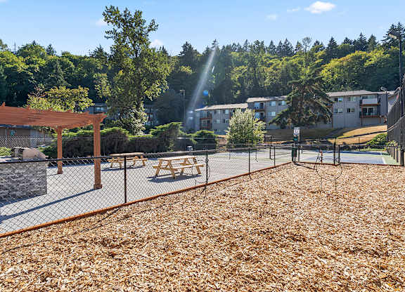 A playground with a wooden structure and a fence.