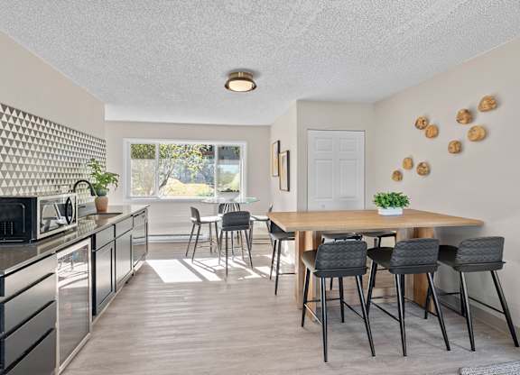 A kitchen with a dining table and chairs.