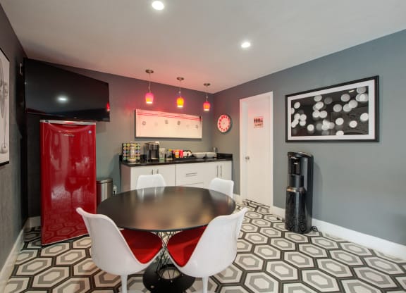a room with a table and chairs and a television at Dwell Apartment Homes, Riverside, 92507