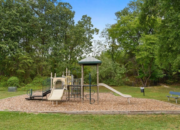 a playground with a swing set and slides in a park at ReNew Odenton, Odenton