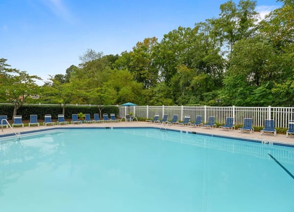 a swimming pool with chairs and trees in the background at ReNew Odenton, Odenton, MD, 21113