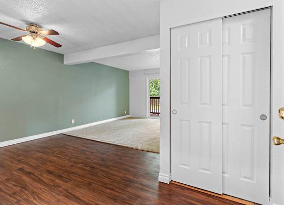 A room with a white door and a ceiling fan.at East Wind, Gresham, 97030