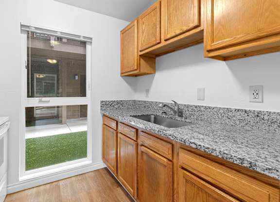 A kitchen with wooden cabinets and granite countertops.at East Wind, Gresham